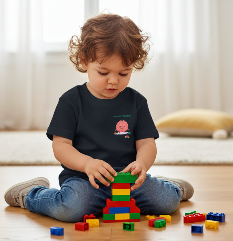 Black t-shirt with a small brain playing with building blocks graphic on a wooden floor
