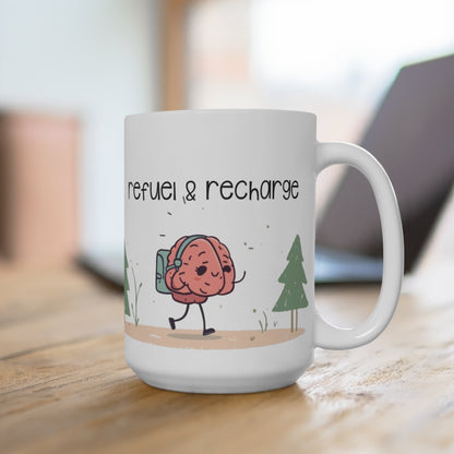 White mug with a cartoon brain character and 'refuel & recharge' text on a wooden surface.