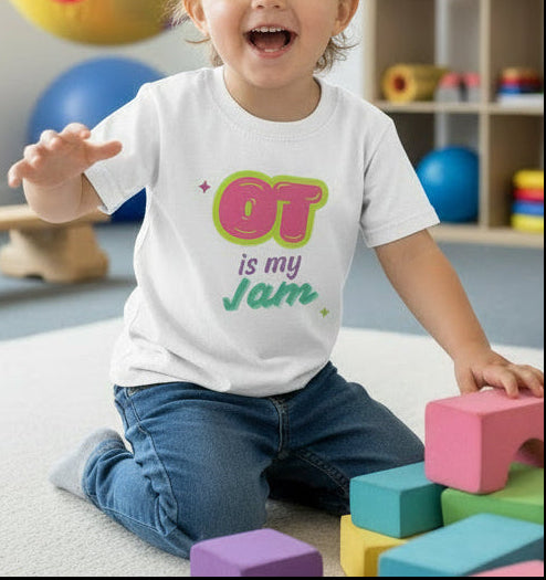 White t-shirt with 'OT is my Jam' text in colorful letters on a white clinic background, kid playing in occupational therapy