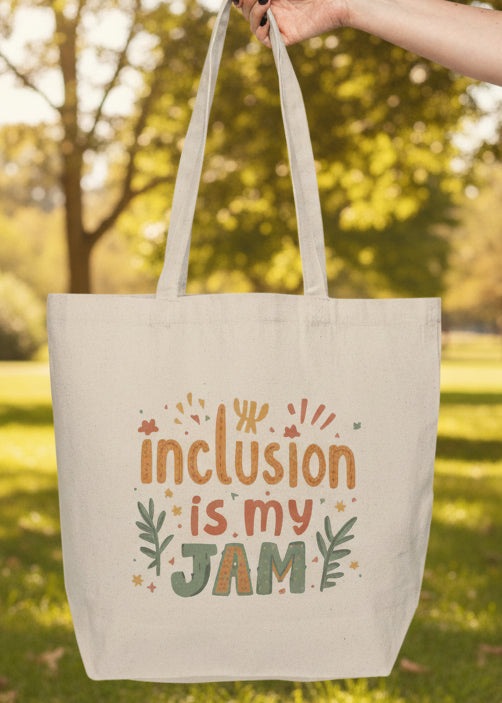 Tote bag with 'Inclusion is my JAM' text held by a hand on park outdoor background