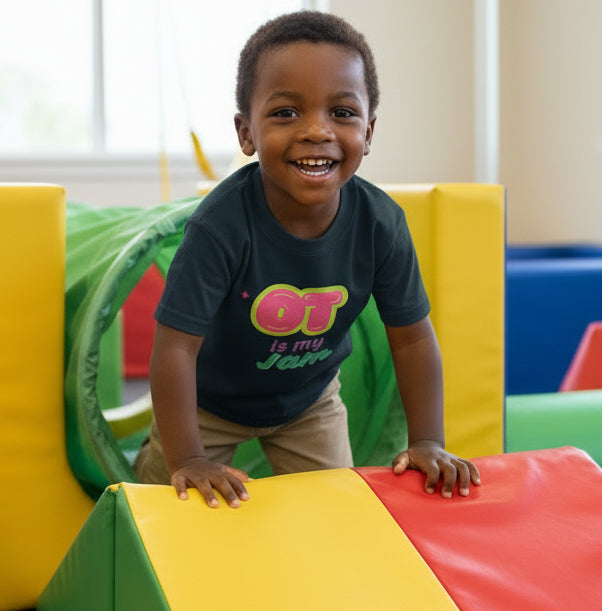Navy blue t-shirt with colorful text design on a little boy crawling over an obstacle course looking happy