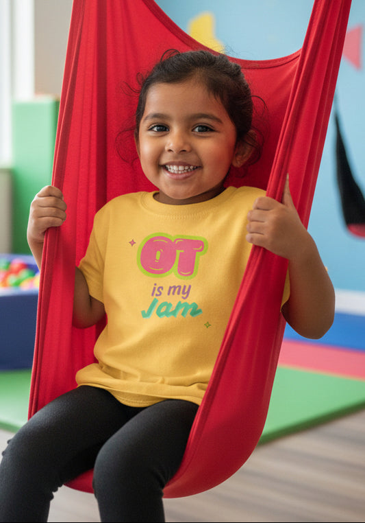 Yellow t-shirt with 'OT is my Jam' text on a child with brown skin in a red swing looking happy