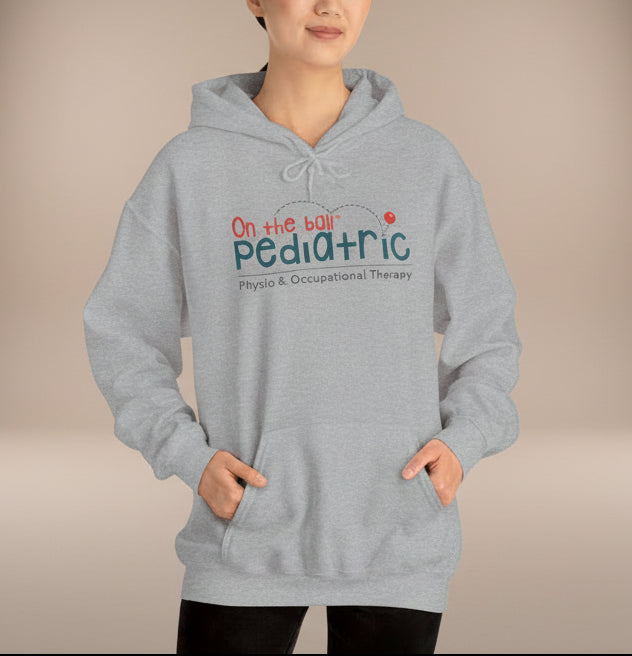 Person wearing a gray hoodie with 'On the Ball Pediatric' text on a white background